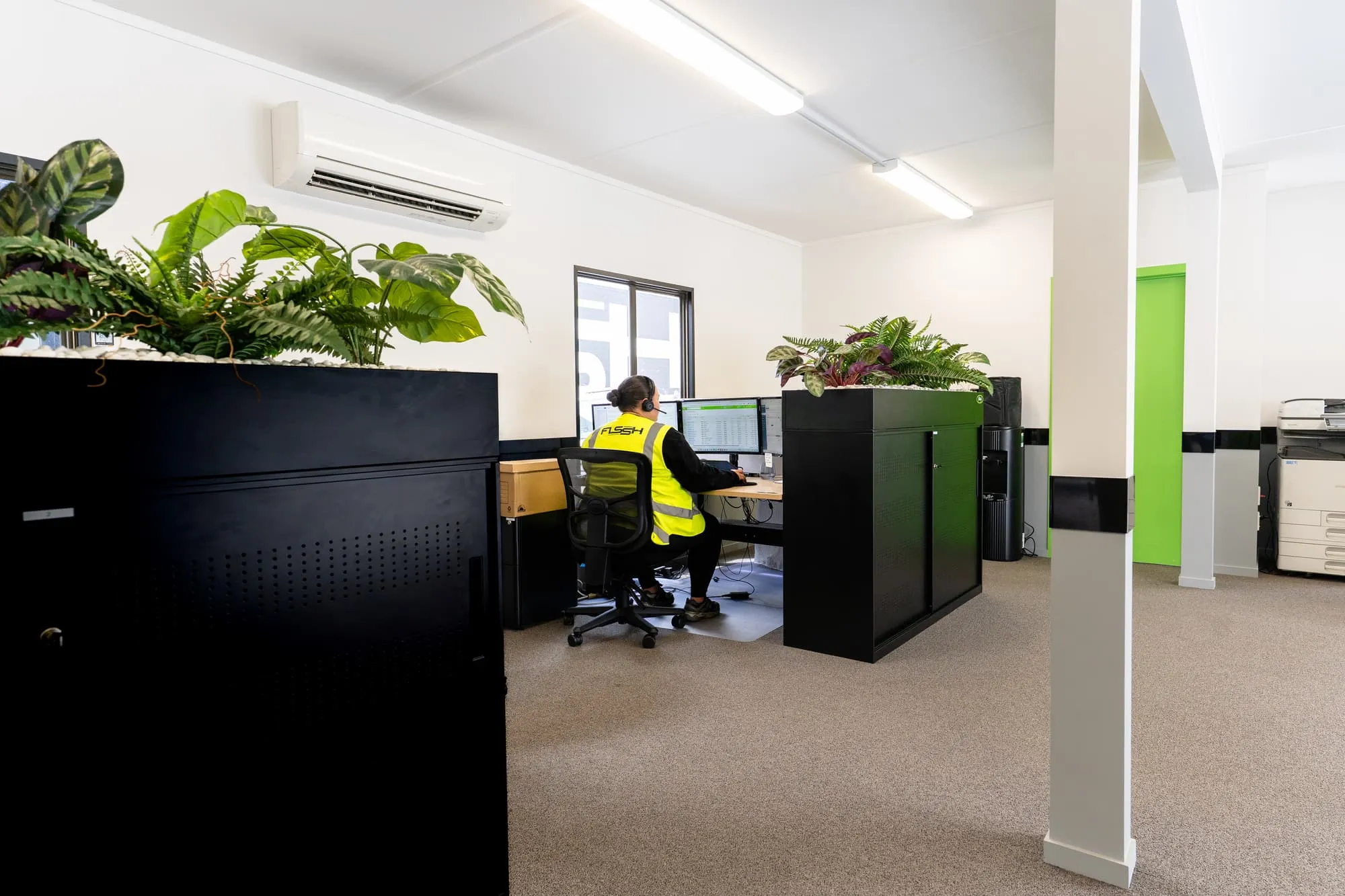 FLSSH team member in hi-vis working at a desk in the Henderson office