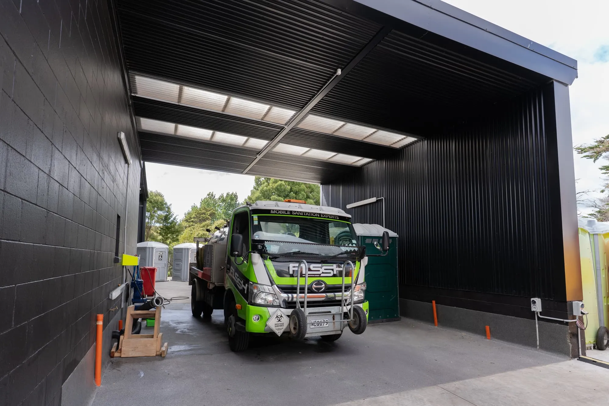 An FLSSH service truck heading out from under the depot canopy